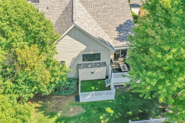 an aerial view of residential houses with outdoor space and trees