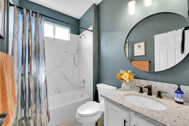 a bathroom with a granite countertop sink toilet and shower