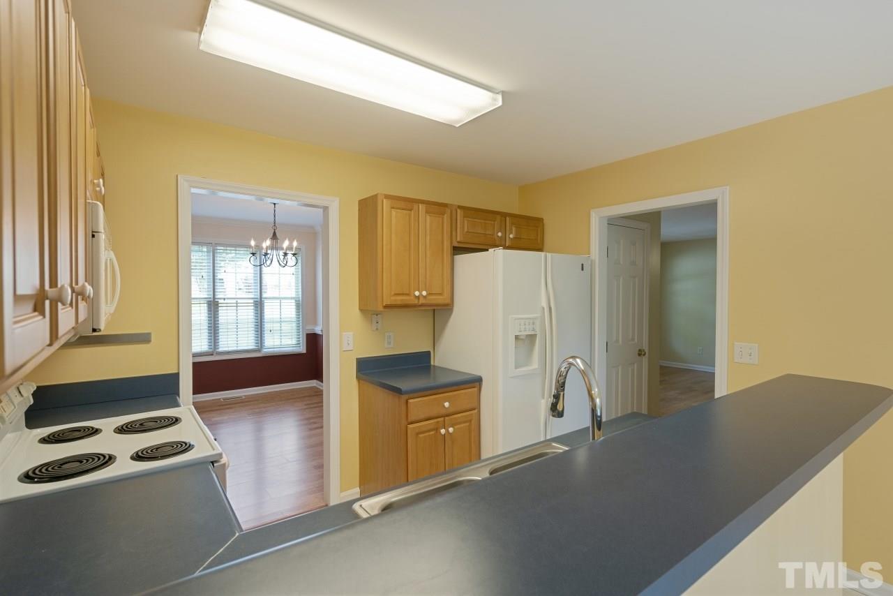 710 Windcrest Road Durham, NC 27713 - Photo 11 of 30 a kitchen with a refrigerator and white cabinets