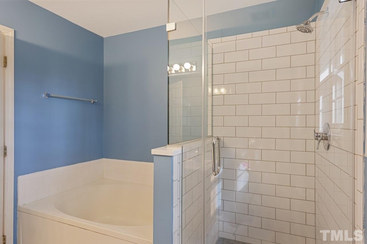 710 Windcrest Road Durham, NC 27713 - Photo 18 of 30 a bathroom with a white bathtub and shower