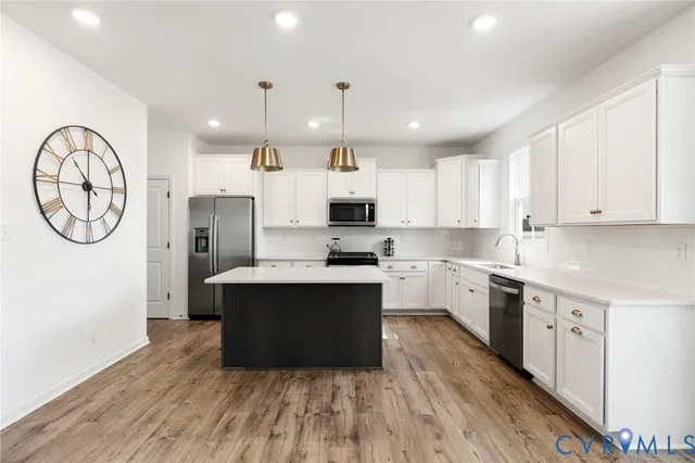 a large kitchen with stainless steel appliances granite countertop a stove and a refrigerator