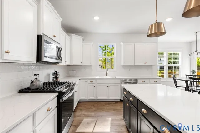 a kitchen with a sink a stove and cabinets