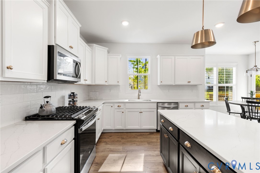 10001 Craftsbury Drive Midlothian, VA 23112 - Photo 16 of 32 a kitchen with a sink a stove and cabinets