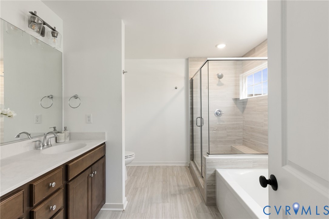 10001 Craftsbury Drive Midlothian, VA 23112 - Photo 22 of 32 a bathroom with a bathtub shower sink vanity and mirror