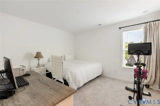 a bedroom with a bed tv and a window