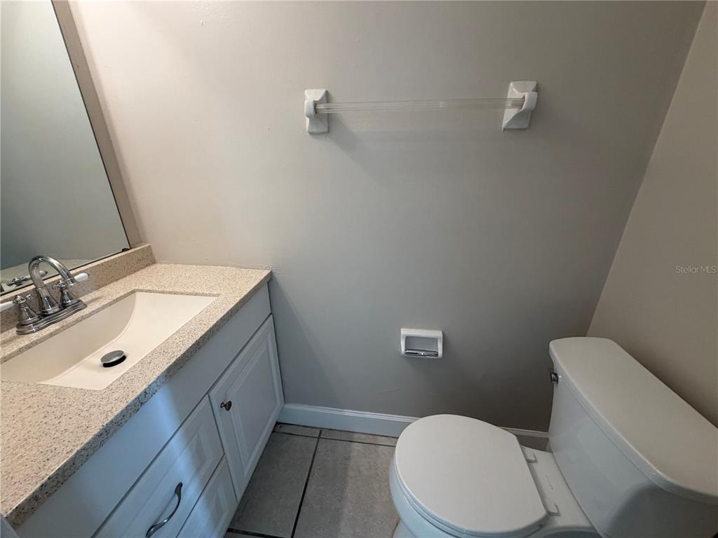 1718 Southwest 69th Terrace, Unit C Gainesville, FL 32607 - Photo 7 of 14 a bathroom with a granite countertop toilet sink and mirror