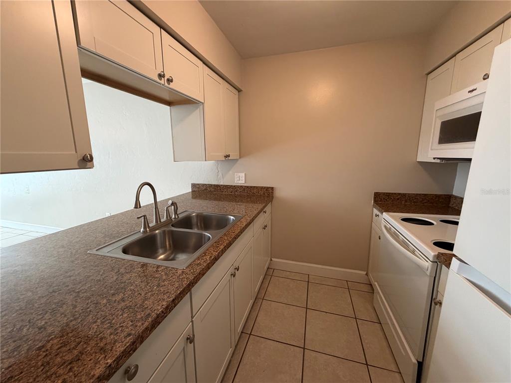 1718 Southwest 69th Terrace, Unit C Gainesville, FL 32607 - Photo 8 of 14 a kitchen with a sink and cabinets