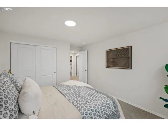 a bedroom with a bed and a painting on the wall