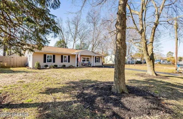a front view of a house with a yard covered with trees