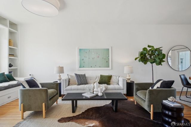 a living room with furniture a rug and a potted plant