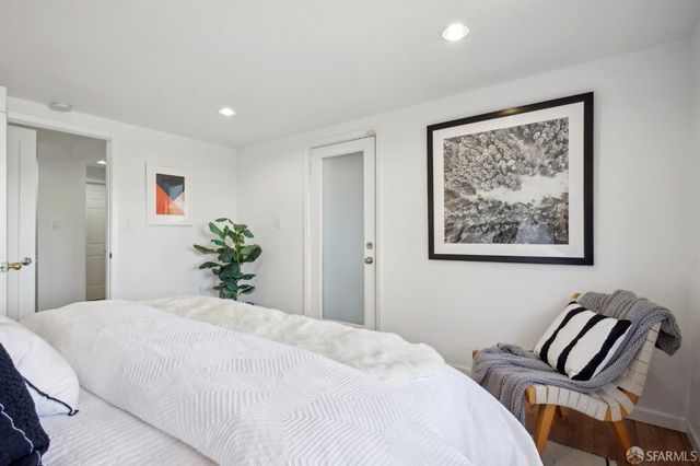 a bedroom with a large bed and a painting on the wall