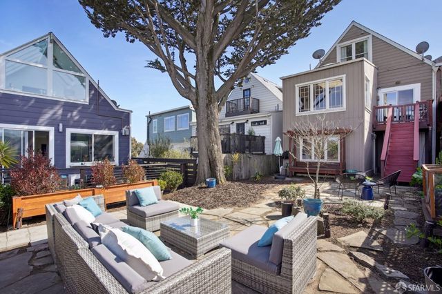 a view of a patio with couches table and chairs and potted plants