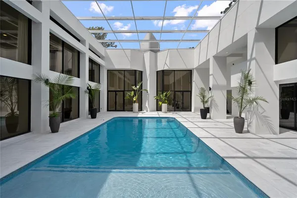 an aerial view of residential house with outdoor space and trees all around