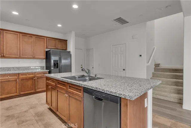 a kitchen with stainless steel appliances granite countertop a sink stove and refrigerator