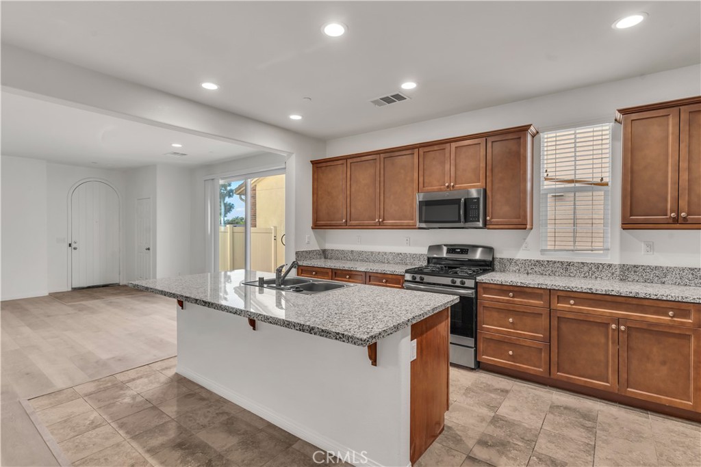 687 South Fillmore Avenue Rialto, CA 92376 - Photo 16 of 39 a kitchen with stainless steel appliances granite countertop a stove a sink and a microwave