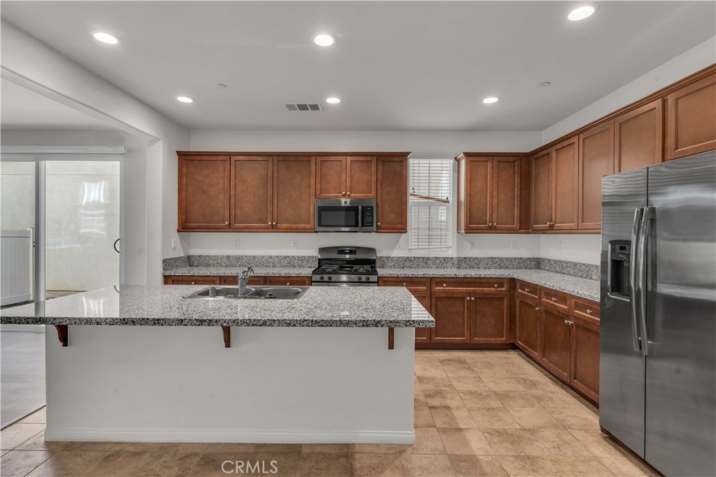 687 South Fillmore Avenue Rialto, CA 92376 - Photo 17 of 39 a kitchen with stainless steel appliances granite countertop a stove a sink a refrigerator a microwave and cabinets