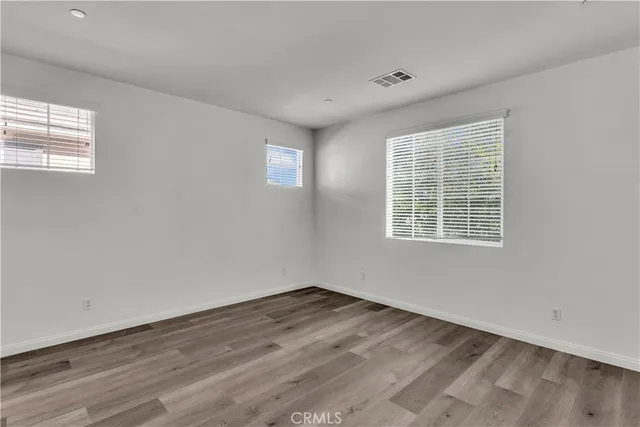 a view of a room with wooden floor and windows