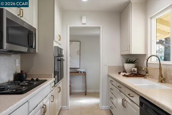 a kitchen with stainless steel appliances a stove sink and microwave