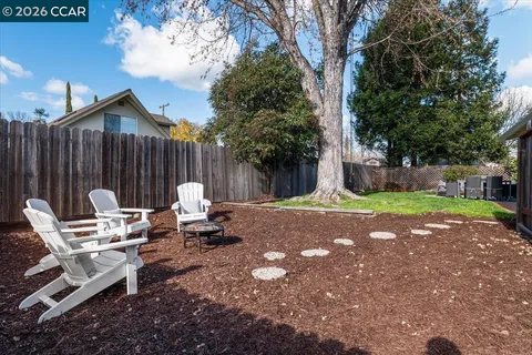 a backyard of a house with table and chairs