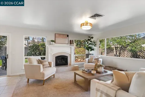 a living room with furniture fireplace and a large window