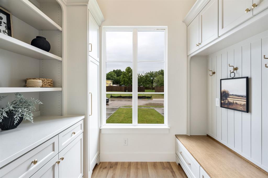 3304 Ferguson Road Grapevine, TX 76092 - Photo 4 of 38 Mudroom featuring white cabinetry, a built-in bench with a wood-finish top, open shelving, and coat hooks