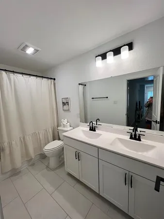 a bathroom with a double vanity sink and a mirror