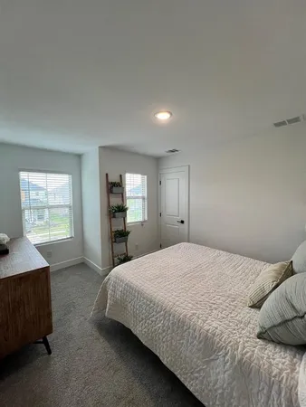 a spacious bedroom with a bed and a window