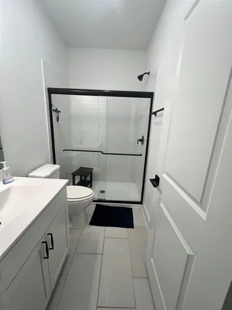 a bathroom with a sink a toilet a mirror and shower