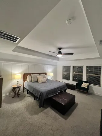 a bedroom with furniture and a large window