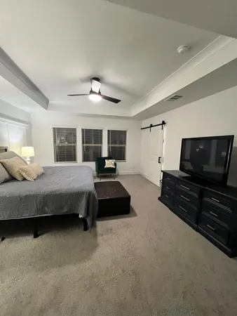 a bedroom with bed and flat screen tv