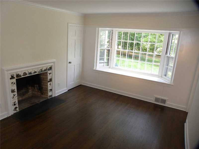 67 Peach Hill Road Darien, CT 06820 - Photo 15 of 25 an empty room with a fireplace and wooden floor
