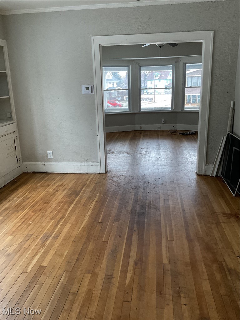 876 Paxton Road Cleveland, OH 44108 - Photo 14 of 26 Empty room featuring ornamental molding, baseboards, and hardwood / wood-style floors