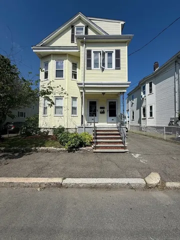 a front view of a house with garage and parking