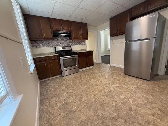 a kitchen with stainless steel appliances granite countertop a refrigerator a stove a sink and a microwave