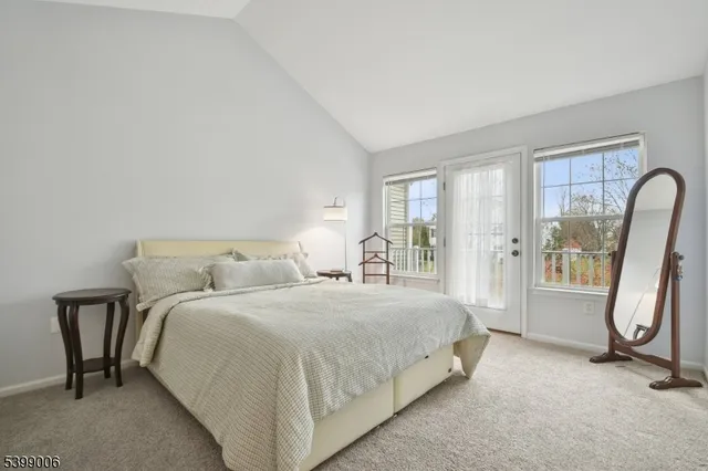 a bedroom with a bed a table and large mirror