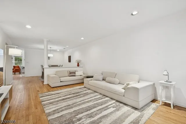 a living room with furniture and a wooden floor