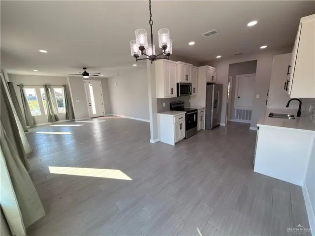 a view of a kitchen with a sink stainless steel appliances and cabinets