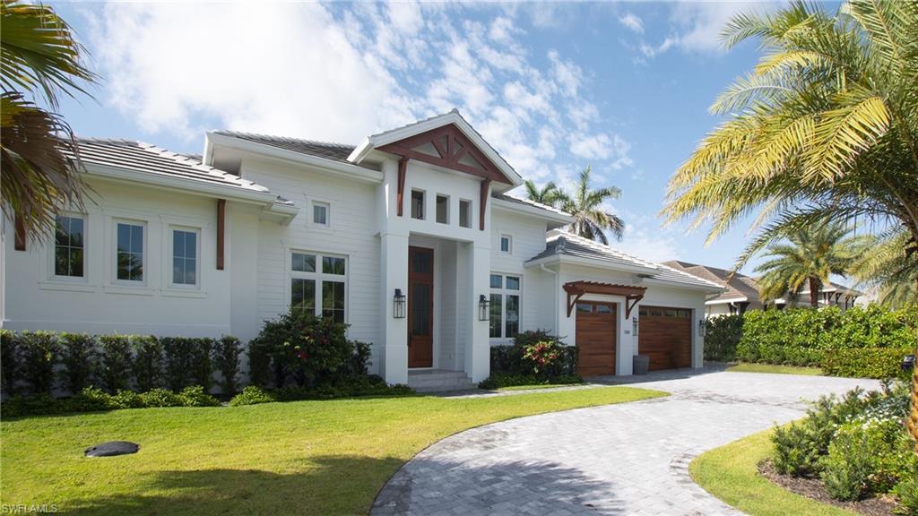 700 Wedge Drive Naples, FL 34103 - Photo 5 of 19 a front view of a house with a yard and potted plants