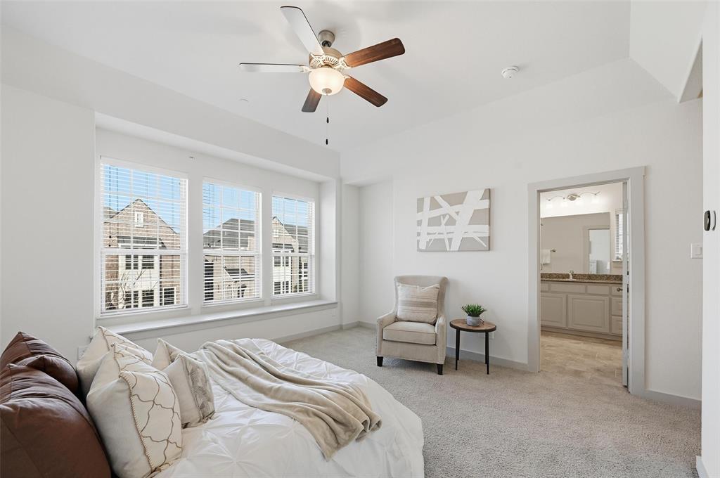4836 Paddock Trail Carrollton, TX 75010 - Photo 21 of 25 a spacious bedroom with a bed a couch and a large window