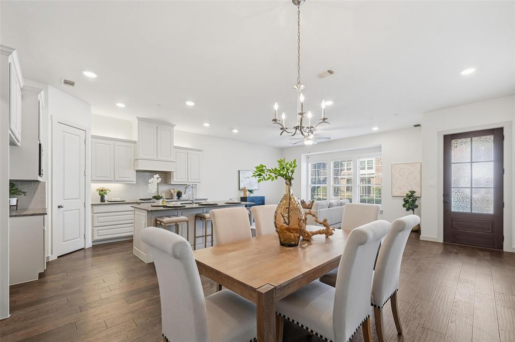 4836 Paddock Trail Carrollton, TX 75010 - Photo 8 of 25 a large kitchen with kitchen island a dining table chairs and white cabinets