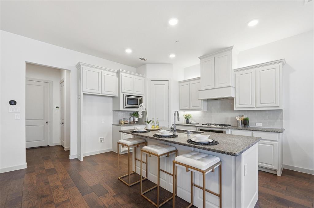 4836 Paddock Trail Carrollton, TX 75010 - Photo 9 of 25 a kitchen with a stove a sink a refrigerator and cabinets