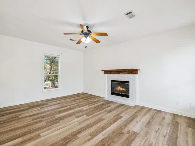 a view of an empty room with window and fireplace
