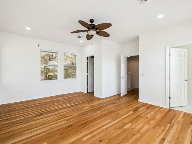 a view of empty room with window and ceiling fan