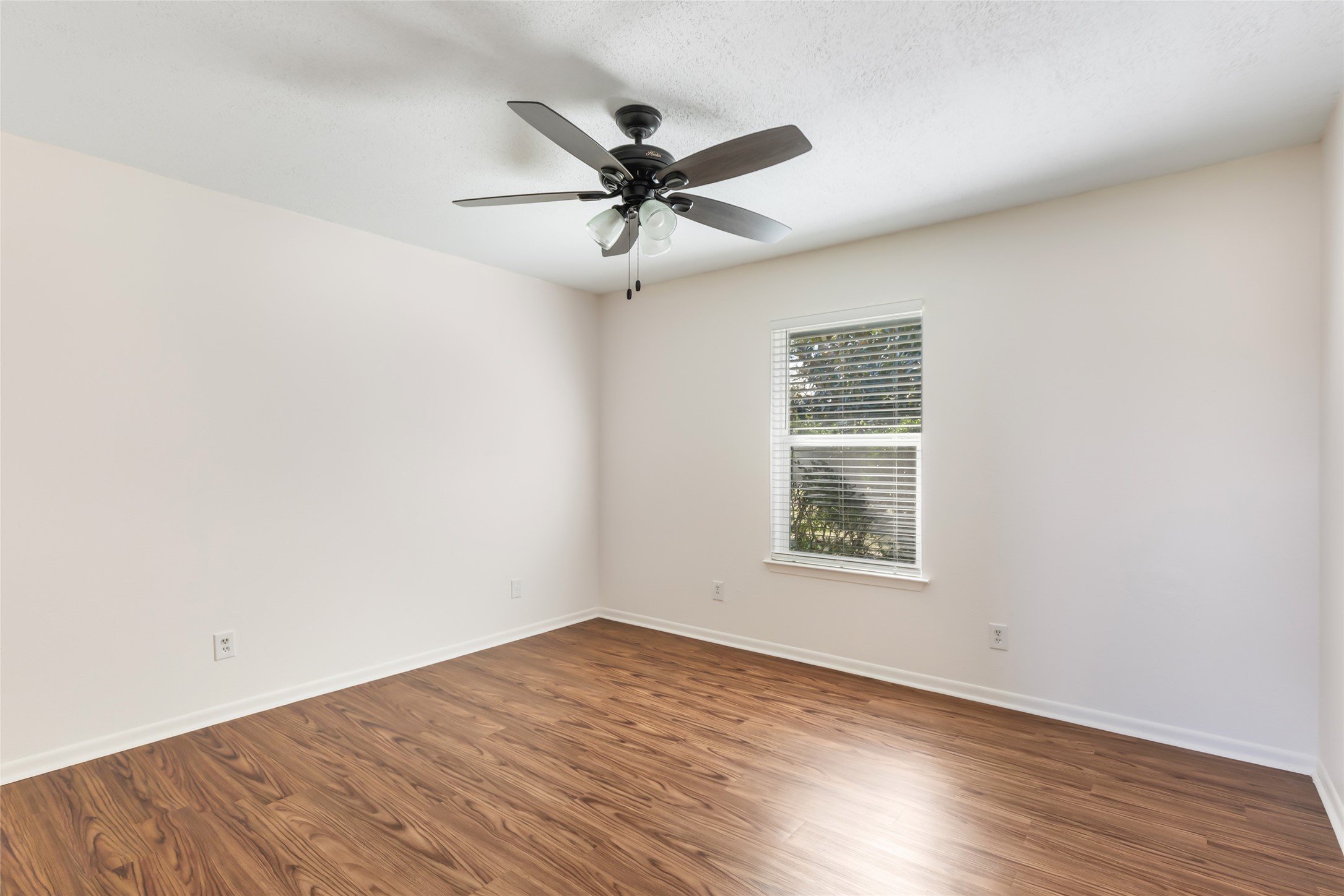 4019 Hillcrest Street Liberty, TX 77575 - Photo 12 of 31 an empty room with wooden floor fan and windows