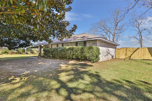 a view of a yard in front of a house with large trees