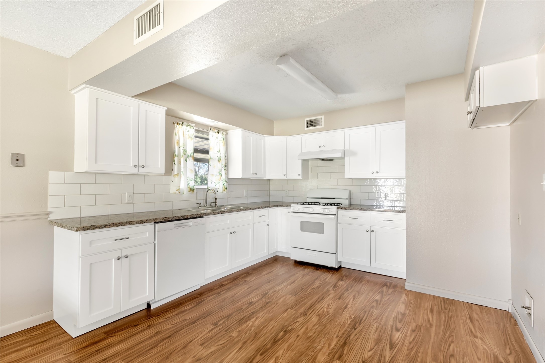 4019 Hillcrest Street Liberty, TX 77575 - Photo 6 of 31 a kitchen with granite countertop white cabinets and white appliances