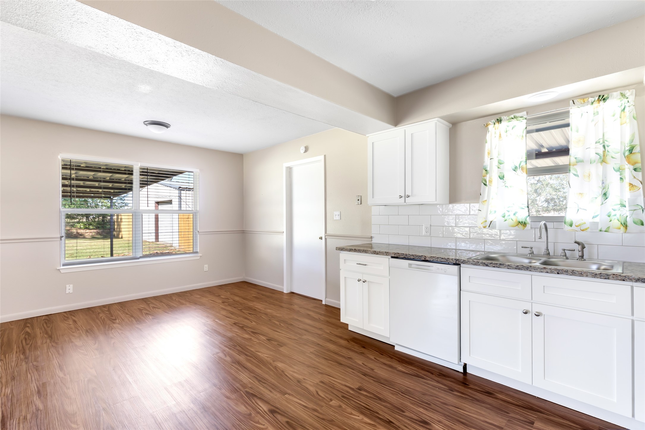 4019 Hillcrest Street Liberty, TX 77575 - Photo 7 of 31 a kitchen with granite countertop wooden floors and wide window