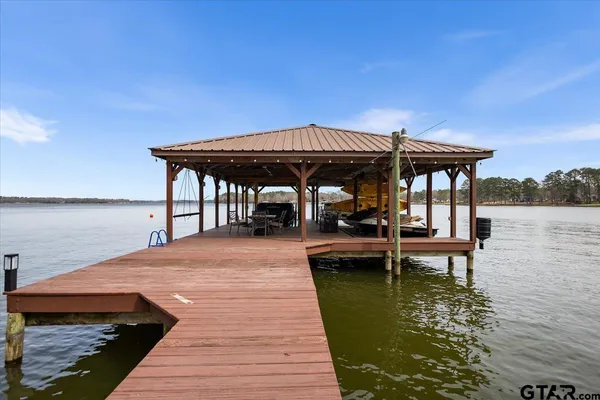 a view of a dining room with furniture a kitchen and chandelier