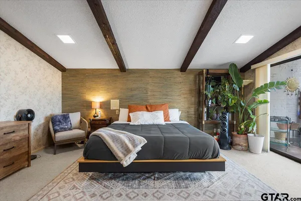 a bedroom with a bed a couch and potted plant