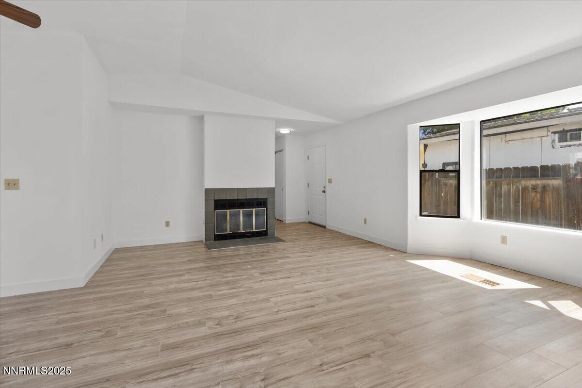 4830 Rampion Way Sun Valley, NV 89433 - Photo 4 of 30 a view of empty room with wooden floor and fireplace